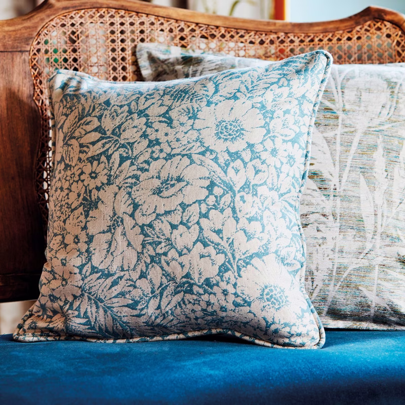 Two patterned cushions on a woven-back sofa, showing the fabric as cushions.