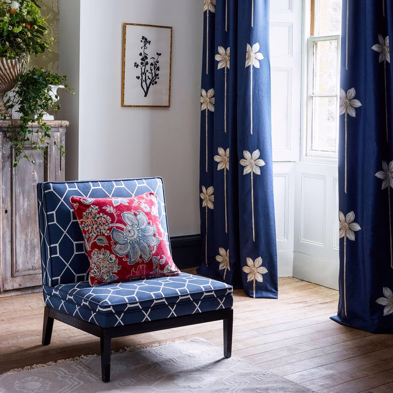 Room with navy floral curtains and a matching upholstered chair with a patterned cushion.