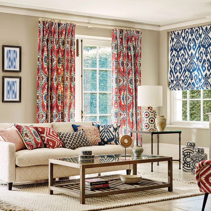 A living room with patterned curtains and cushions, plus a blue patterned Roman blind over the window.