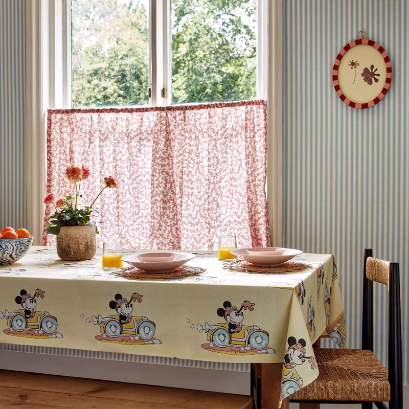 Dining room with a tablecloth and a short gathered curtain at the window, both in Disney Minnie print fabric.