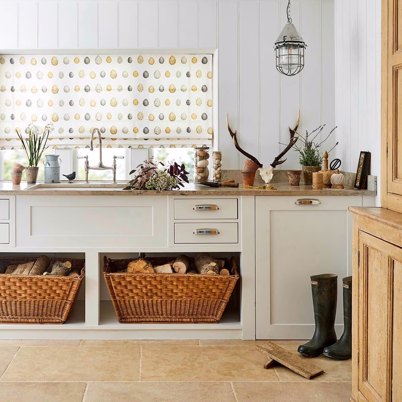 Kitchen with a Roman blind made in a gold-and-cream egg-pattern fabric above the sink.