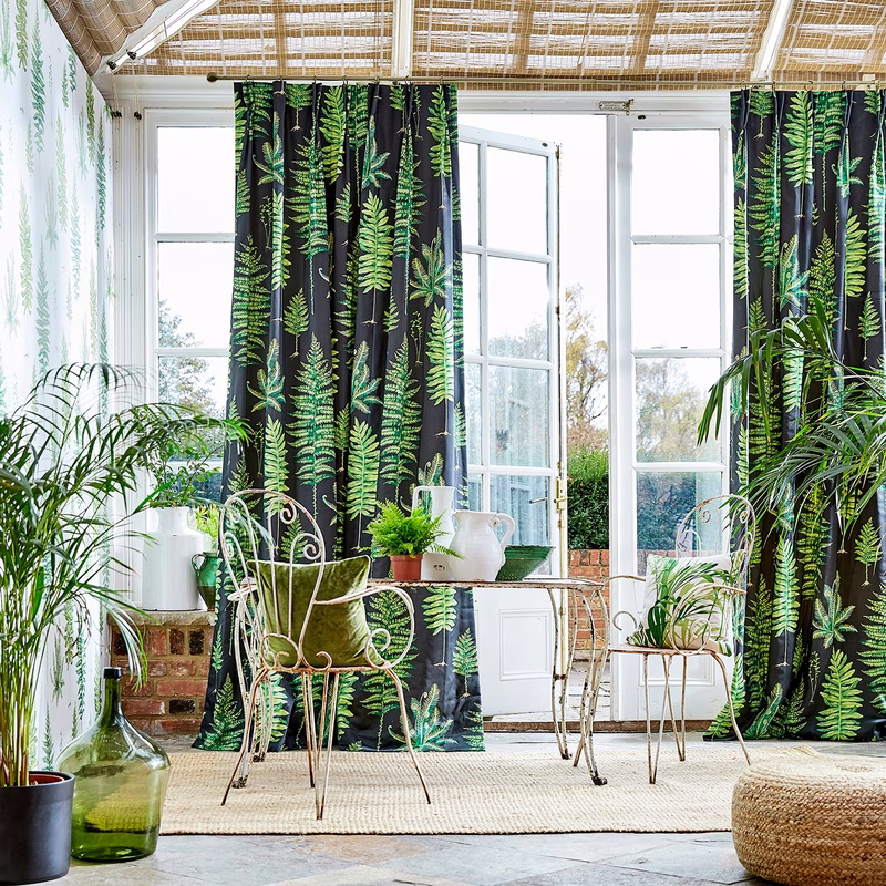 Bright conservatory with Fernery fabric made up as full-length curtains.