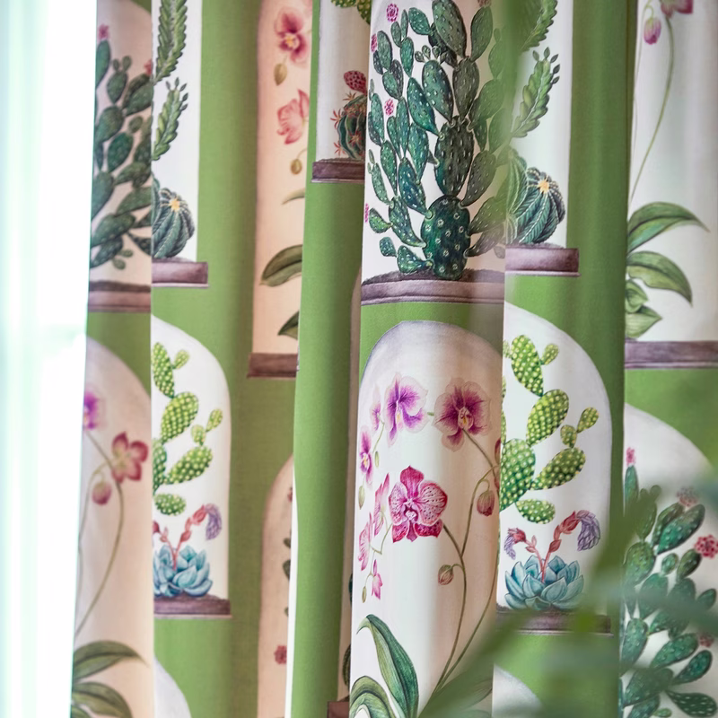 Potted cactus and orchid motifs on hanging curtain panels in a glasshouse-style room.