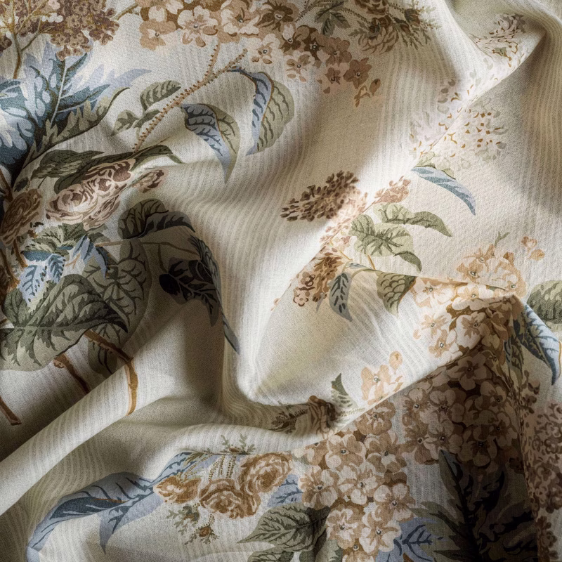 Close-up of floral patterned upholstery fabric draped in soft folds.