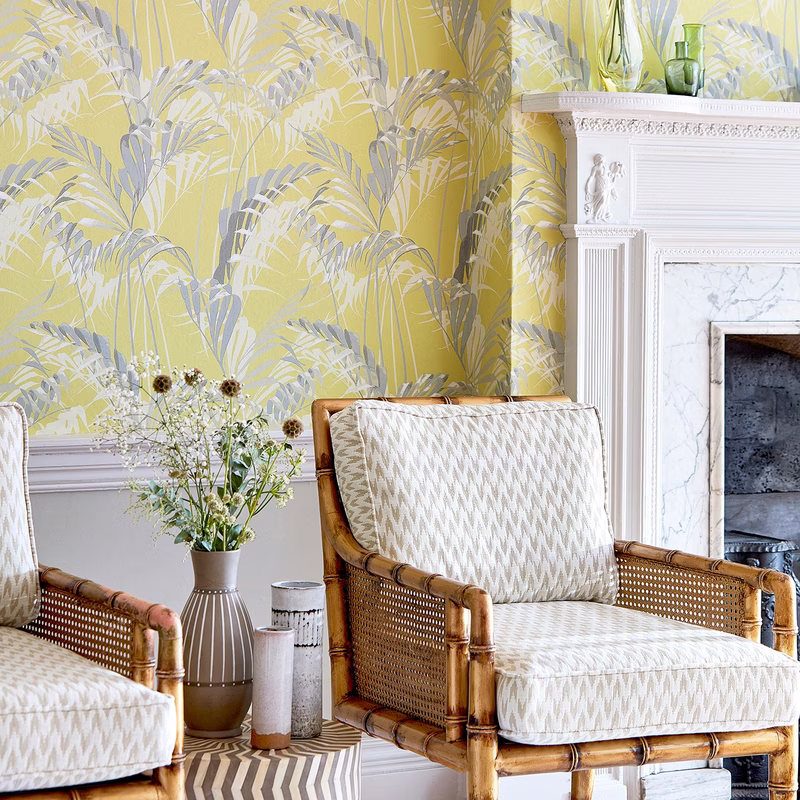 A sitting room with bamboo armchairs upholstered in a pale zigzag fabric, with matching seat and back cushions.