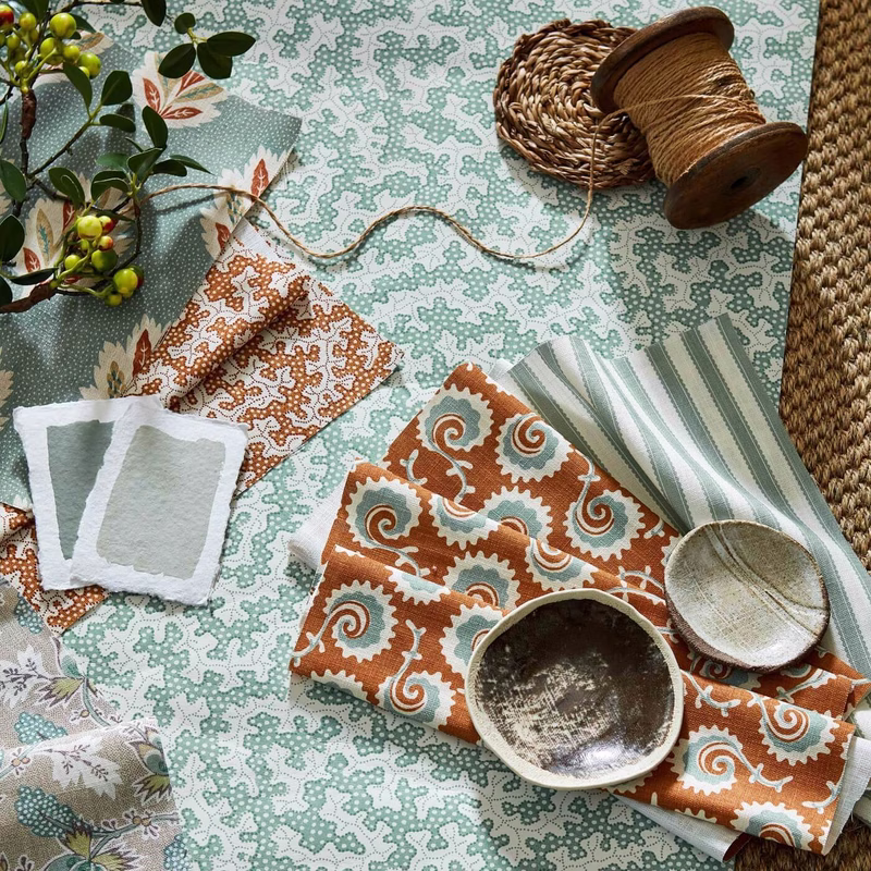 Patterned fabric samples and gardening props laid out on a table, with the Dallimore cloth shown as folded lengths of fabric.