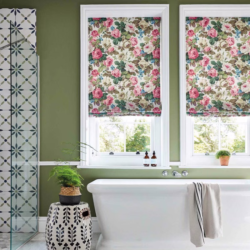 Bathroom with floral Roman blinds at the windows and a patterned curtain or shower screen panel beside the bath.