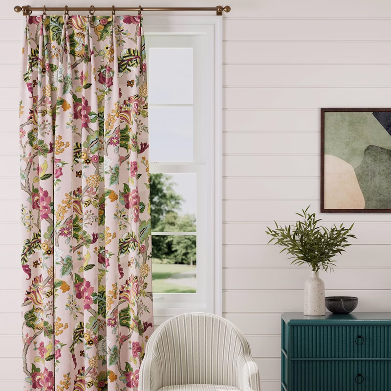A room with floral patterned curtains hung at a window, showing Sanderson Fusang Tree fabric.
