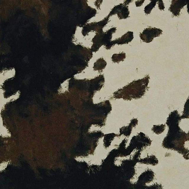 Cream cowhide fabric with blurred black and brown patches and a softly textured surface
