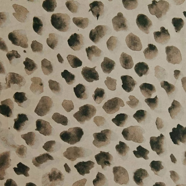 Warm stone textile with scattered charcoal, olive and taupe painterly spots