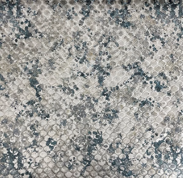 Mottled grey-blue textile with small looping motifs and a softly raised surface