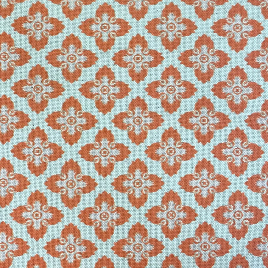 Turquoise woven fabric with repeating rust medallions and cream scroll details
