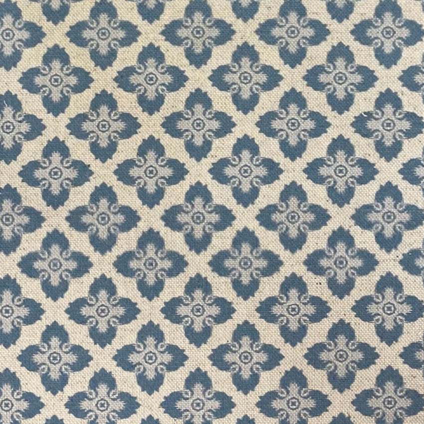 Blue-grey ornamental quatrefoils repeating across a softly textured cream woven fabric