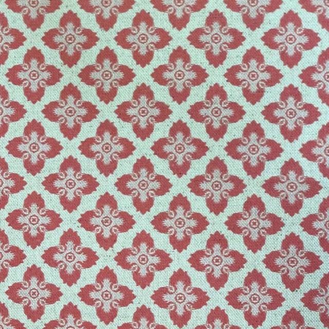 Mint-aqua woven fabric with repeating melon-red floral medallions and cream scrollwork
