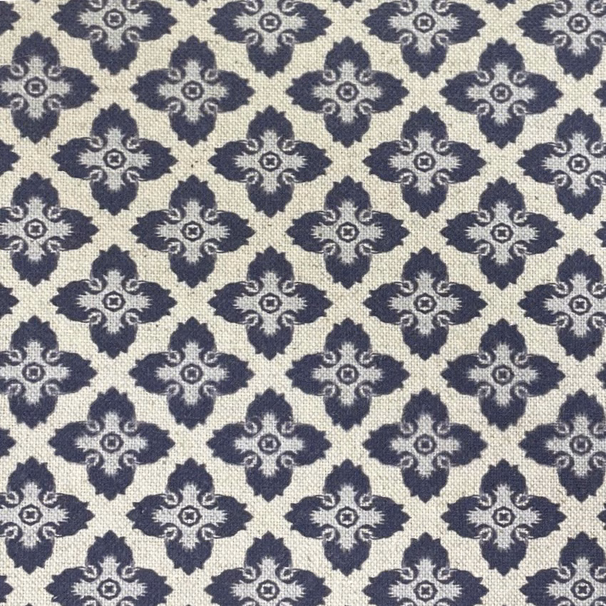 Cream woven fabric with repeating charcoal-blue quatrefoil motifs and textured surface