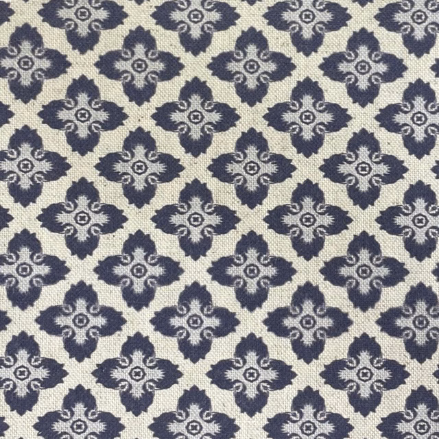 Cream woven fabric with repeating charcoal-blue quatrefoil motifs and textured surface