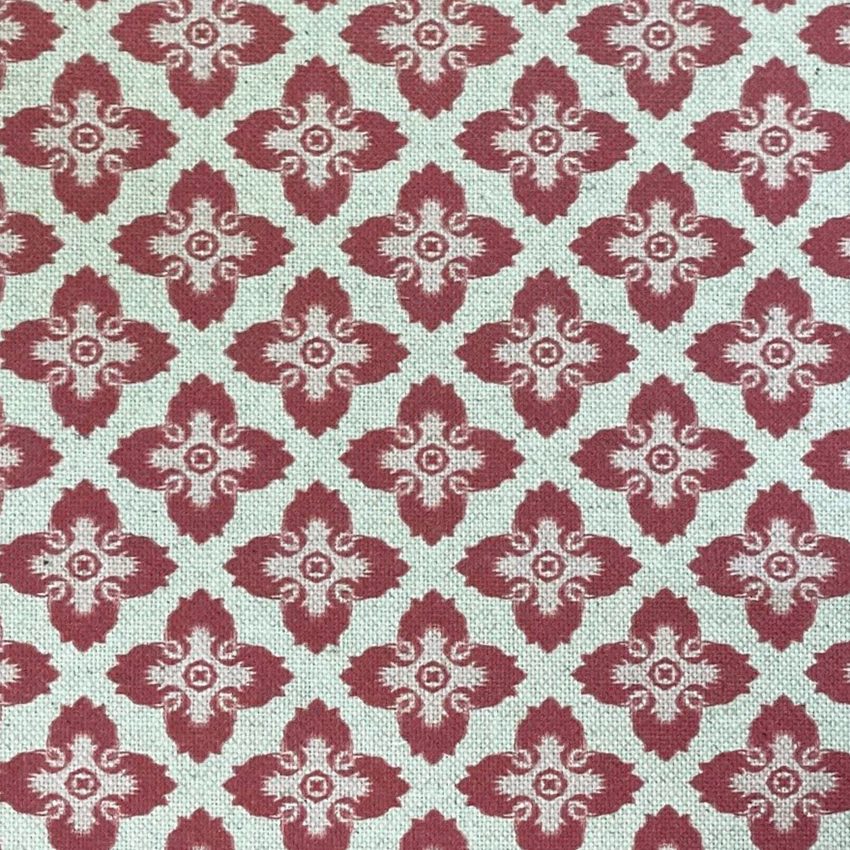 Raspberry-red quatrefoil motifs on a softly textured ivory woven ground
