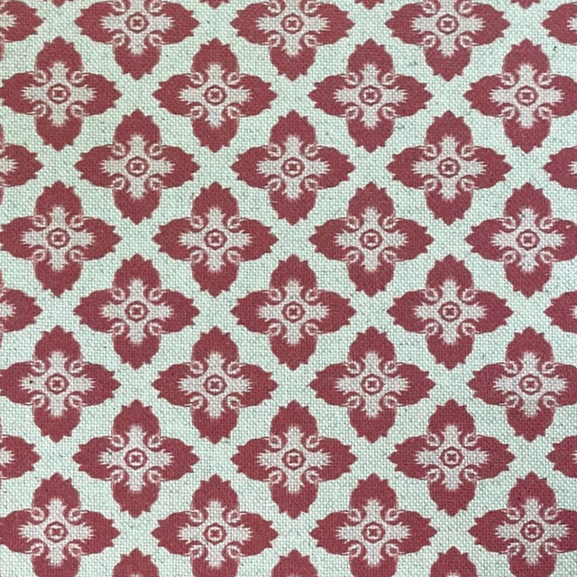 Raspberry-red quatrefoil motifs on a softly textured ivory woven ground