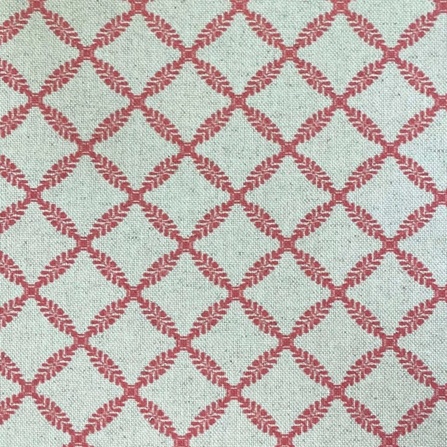 Pale mint woven fabric with a melon-red diamond trellis pattern and flecked texture
