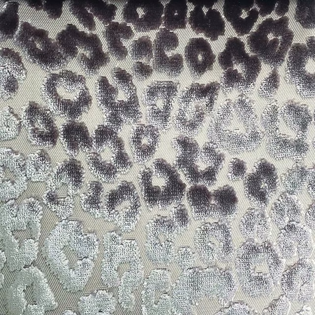 Warm ivory woven fabric with charcoal and smoky-grey cheetah rosettes