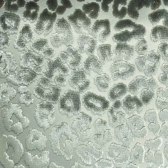 Pale sage-grey woven cheetah spots with softly raised, shadowed tonal markings