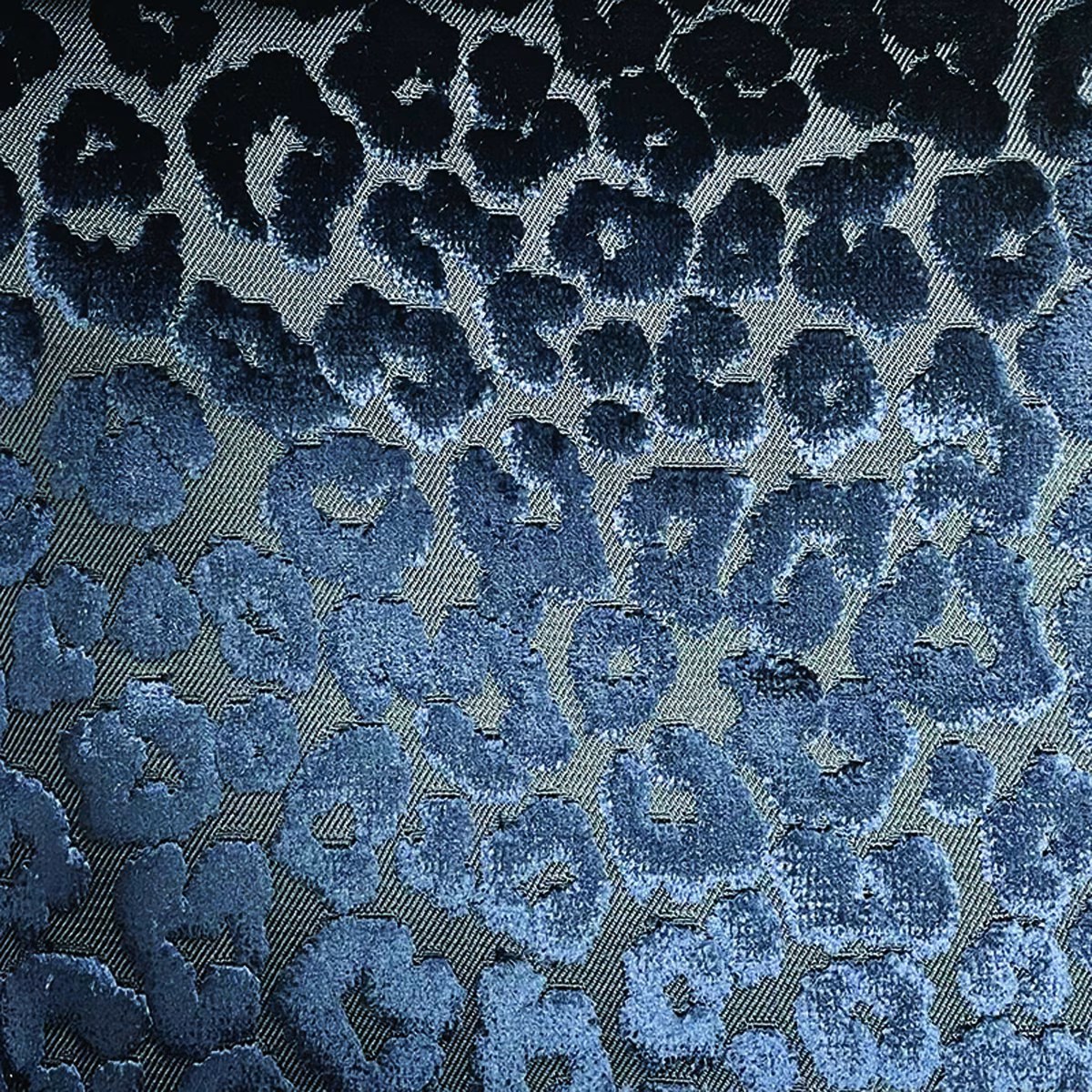 Close-up of navy and denim cheetah spots woven across a blue-grey ground