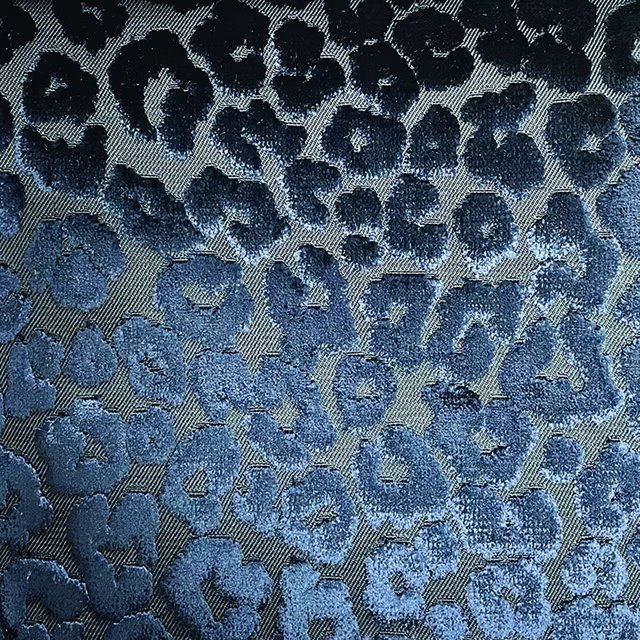 Close-up of navy and denim cheetah spots woven across a blue-grey ground