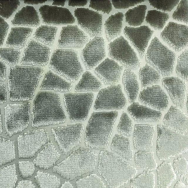 Sage-grey woven textile with irregular pale mosaic cells and raised texture