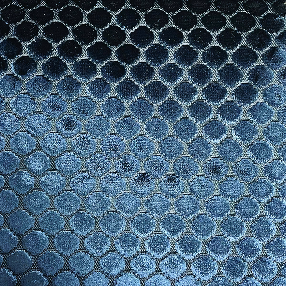Close-up of navy and denim-blue rounded spots in a shimmering lattice weave