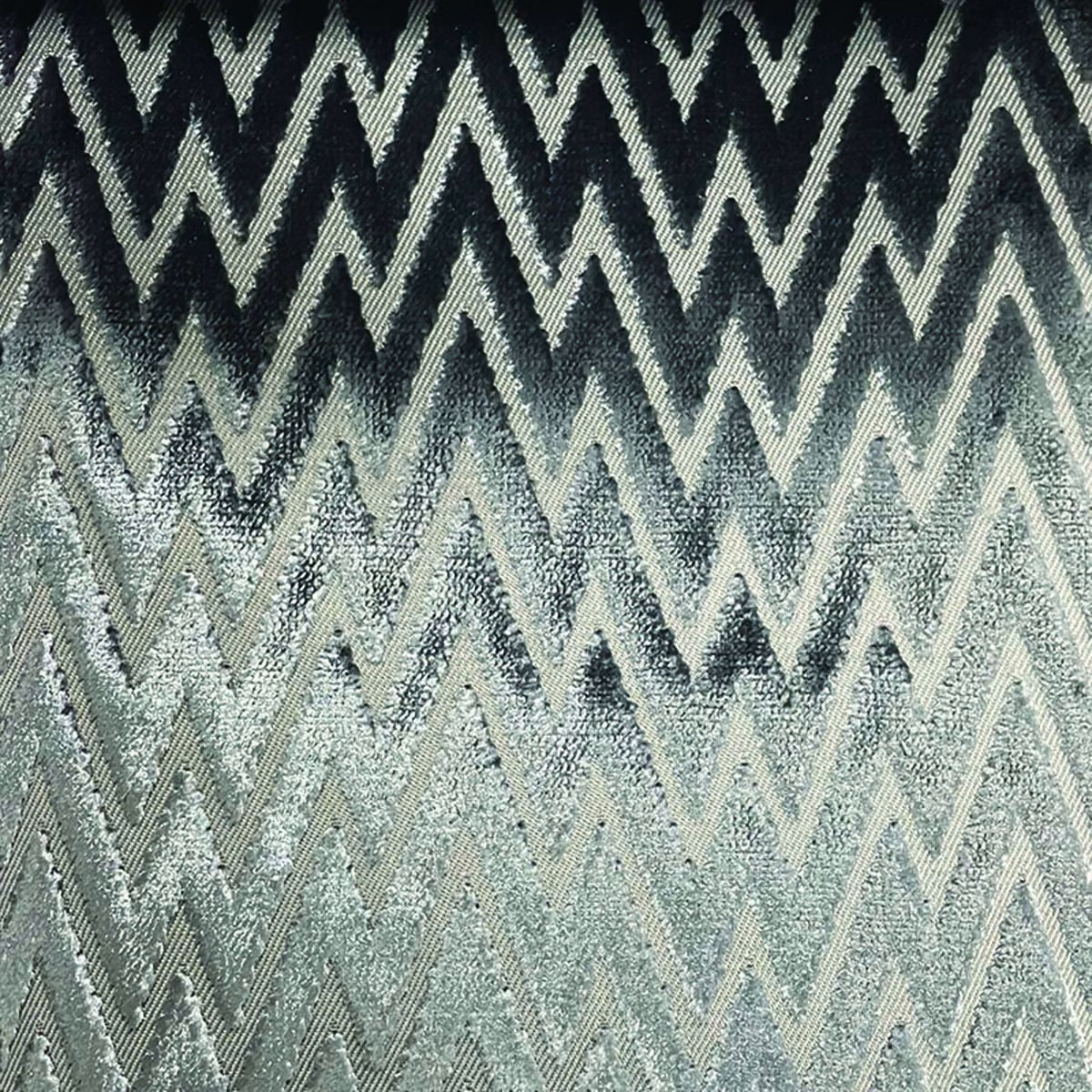 Cool blue-grey and charcoal woven textile with layered pale zig-zag chevrons