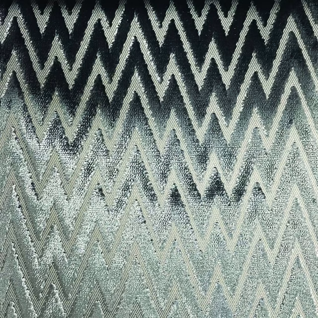 Cool blue-grey and charcoal woven textile with layered pale zig-zag chevrons