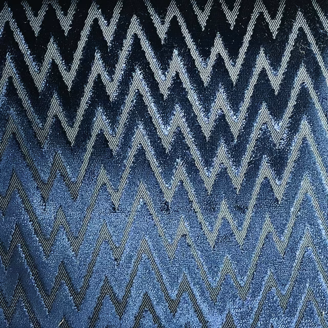 Denim-blue woven textile with charcoal and silver zigzag chevrons