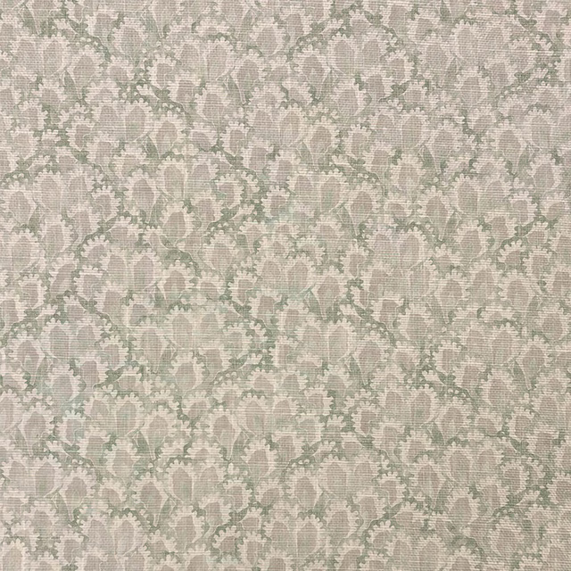 Close-up of pale sage botanical fabric with ivory flowers and fine woven texture