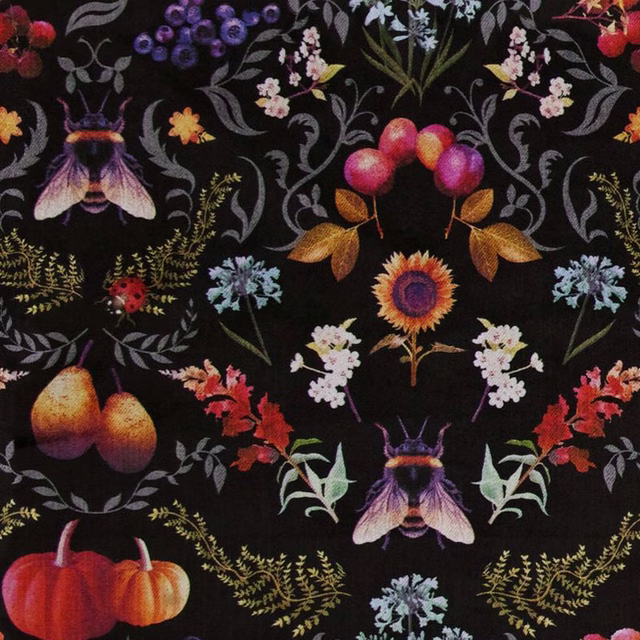 Black fabric with jewel-toned berries, bees, sunflowers and curling botanical foliage