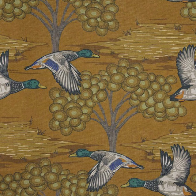Mustard-ochre fabric with flying mallards, blossom trees and pale water ripples