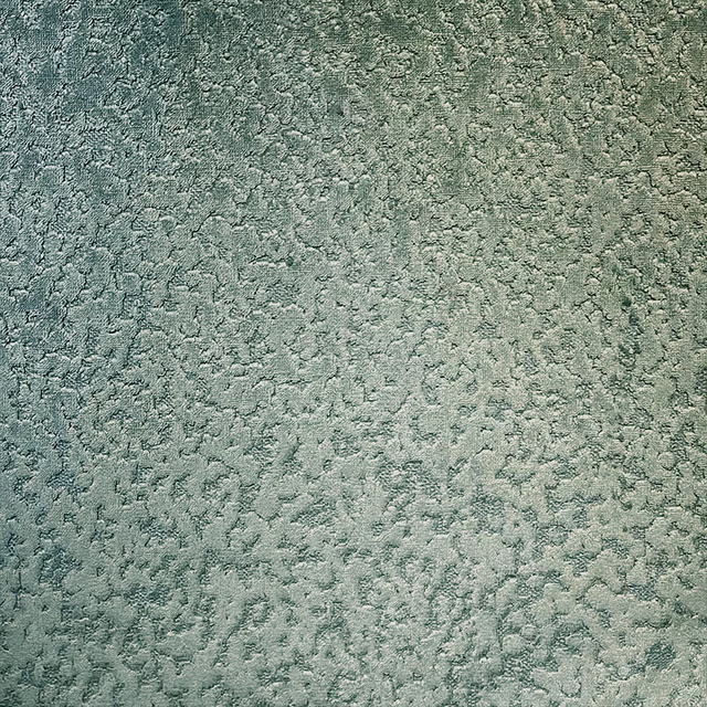 Mottled forest green textile with softly raised, pebble-like texture and pale sage highlights