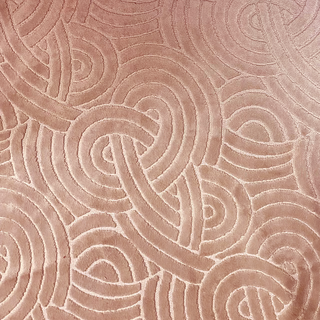 Dusty blush textile with pale raised looping paisley lines and sculpted texture