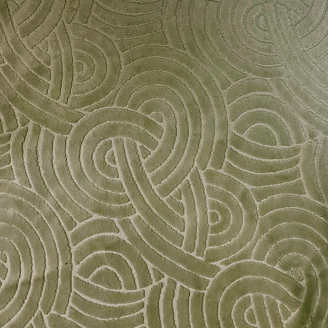 Muted olive-green textile with raised interlocking loops and softly tactile tonal texture