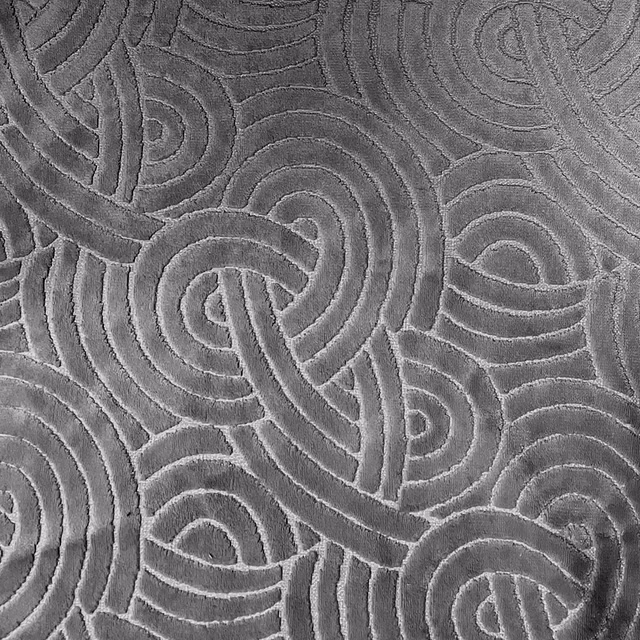 Charcoal-grey fabric with raised interlocking loops and tonal maze-like texture