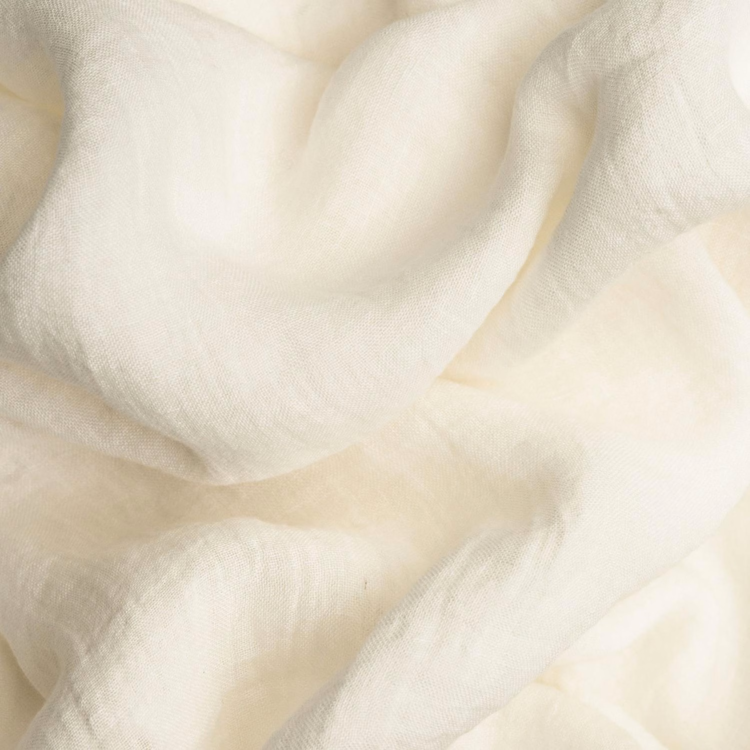 Warm white finely woven fabric draped in soft translucent folds with creamy shadows