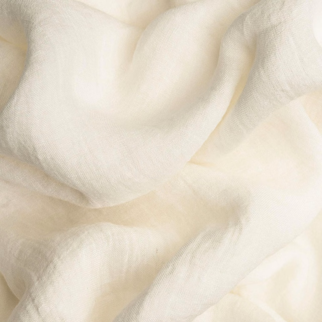 Warm white finely woven fabric draped in soft translucent folds with creamy shadows