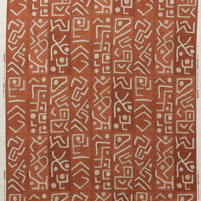 Warm brick-red textile with repeated chalk geometric maze motifs and visible weave