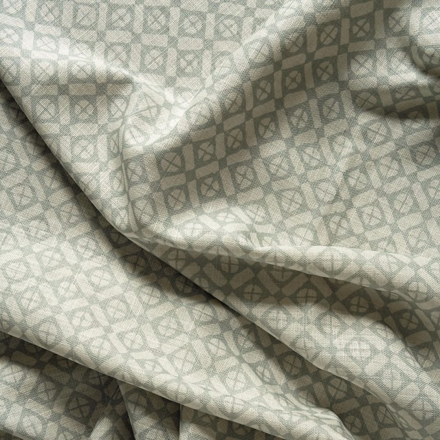 Powder sage-grey woven fabric with small interlocking geometric motifs and soft folds