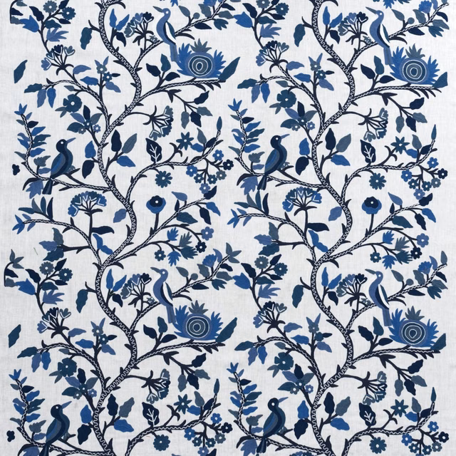 Blue-and-white embroidered branches with birds, flowers and curling foliage on a pale ground