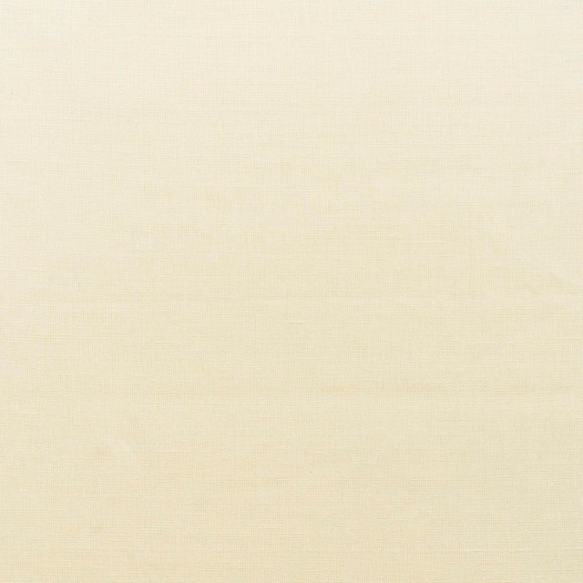 Close view of warm ivory plain-woven fabric with a fine, softly irregular texture