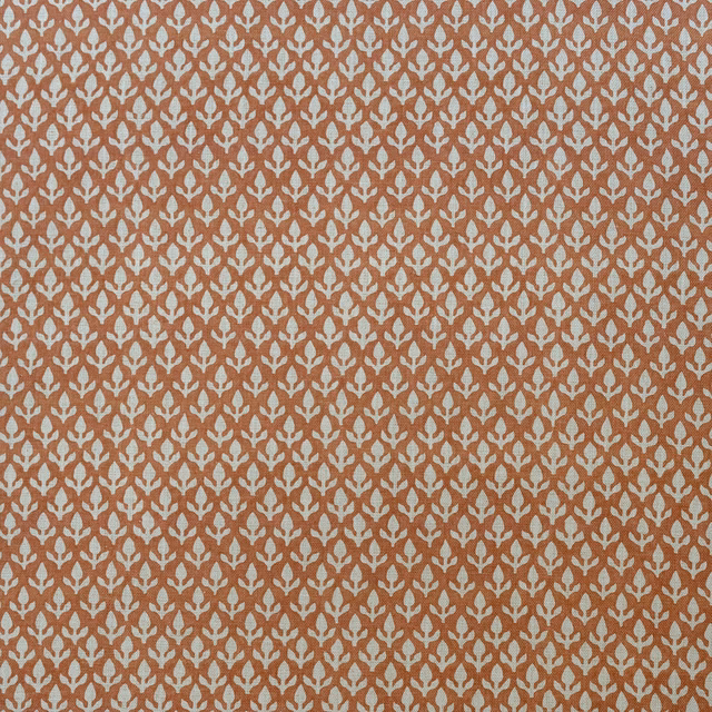 Burnt orange woven fabric with a small repeating cream bud motif
