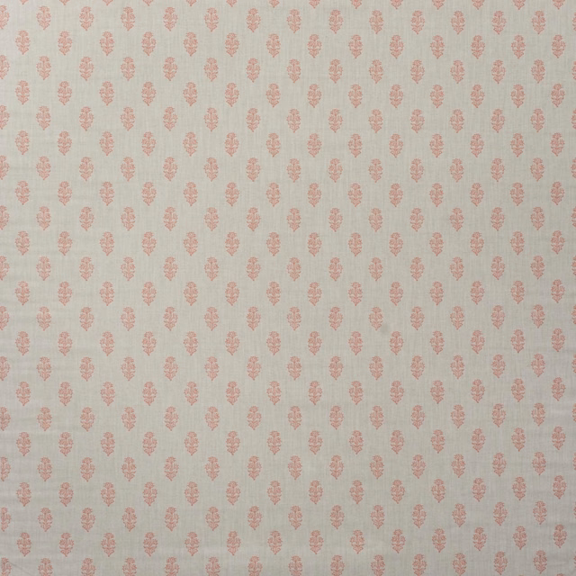 Pale warm cream cotton with evenly spaced muted coral botanical motifs and subtle woven texture