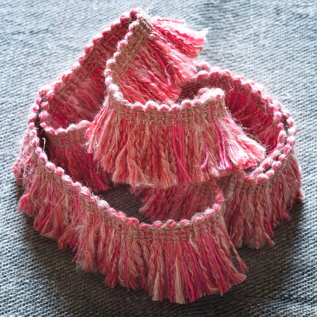 Raspberry pink fringe trim with shaggy strands and woven taupe edging