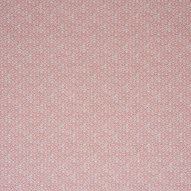 Dusty rose pink fabric with tiny pale scalloped floral motifs in a close repeat