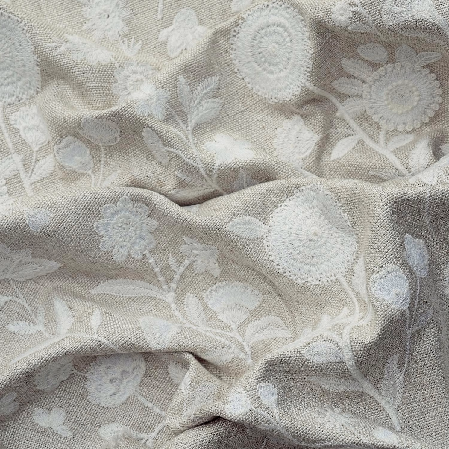 Ivory floral fabric with pale raised blossoms on a softly textured woven ground